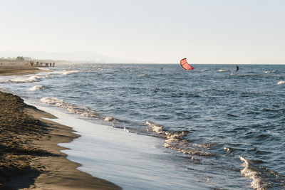 Summer afternoon on the beach with people doing kitesurf in mediterranean sea, oliva, valencia