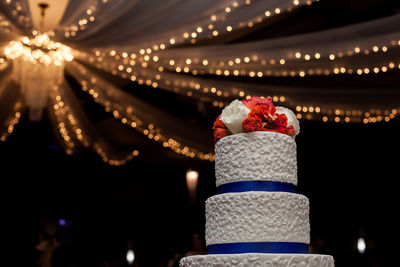 Wedding cake against illuminated decorations at night