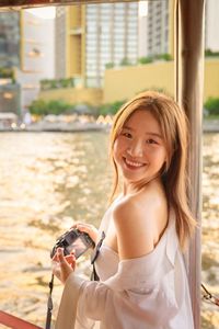 Portrait of smiling young woman with dog in city