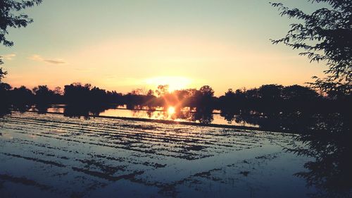 Scenic view of lake against sky during sunset