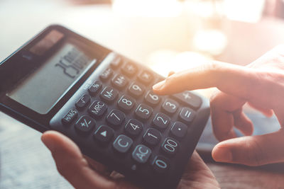 Close-up of person using calculator