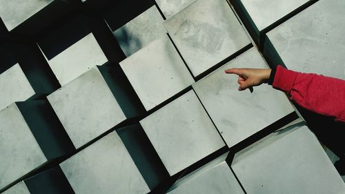 Close-up of hand pointing towards blocks