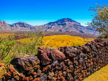 Scenic view of rocky mountains against blue sky