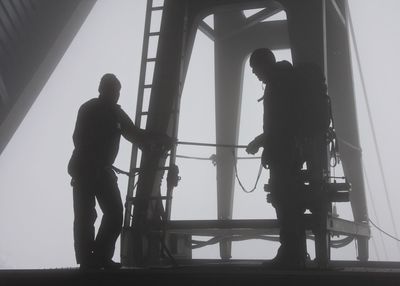 Two men standing by architectural structure