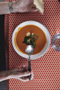 Directly above view of senior man eating fresh soup at dining table