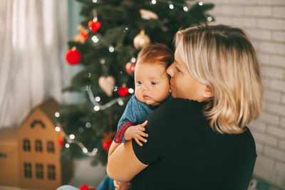 Mother holding baby boy at home