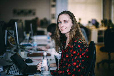 Portrait of young woman sitting on table