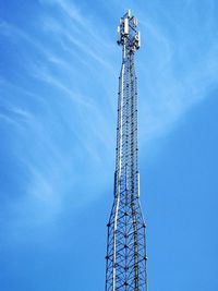 Low angle view of communications tower against blue sky