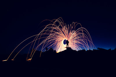 Low angle view of fireworks against sky at night