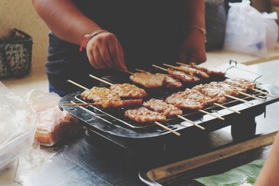 Person preparing food on barbecue grill