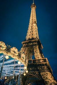 Low angle view of illuminated tower against blue sky