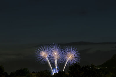 Low angle view of firework display at night