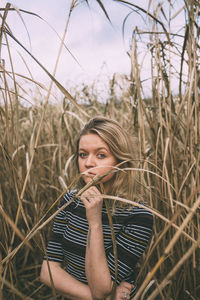 Portrait of beautiful young woman standing amidst plants