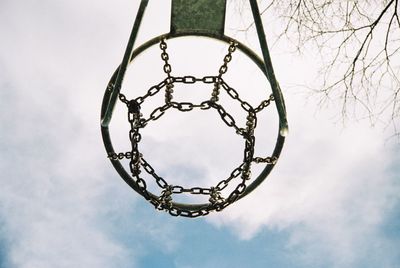 Directly below shot of basketball hoop against cloudy sky