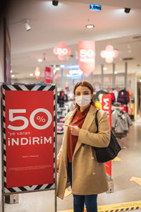 Full length portrait of woman standing in store