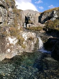 Scenic view of waterfall against sky