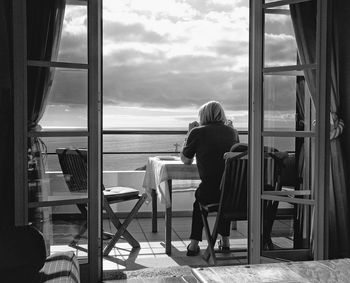 Rear view of woman overlooking calm sea