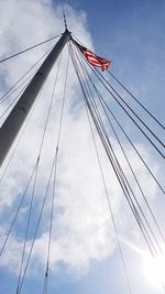 Low angle view of crane against cloudy sky