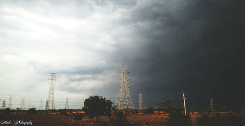 Low angle view of power lines against cloudy sky