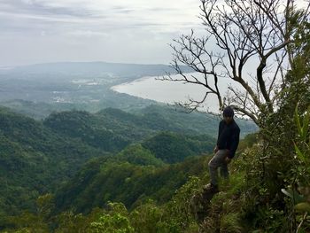 Man standing on mountain against sky