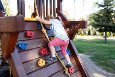 Girl playing on jungle gym at playground