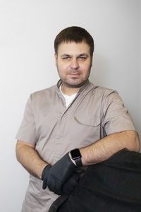 Portrait of young man sitting against white background