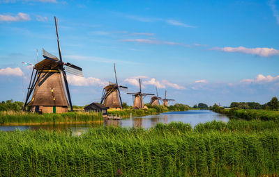 Traditional windmill on landscape against sky