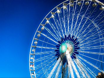 Low angle view of ferris wheel against blue sky