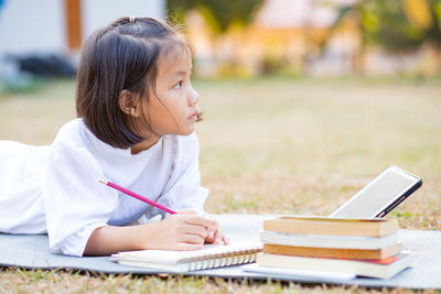 Rear view of a girl sitting on book