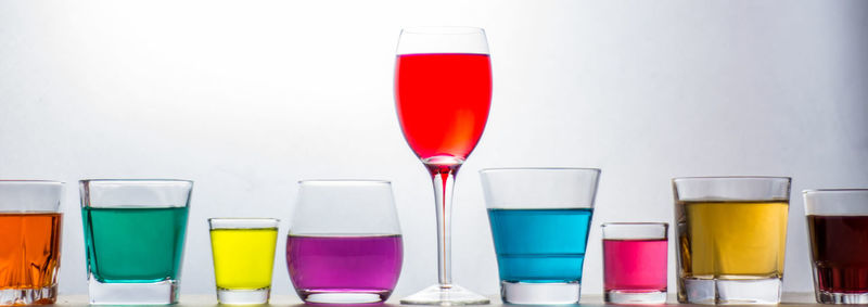 Close-up of multi colored glasses against white background