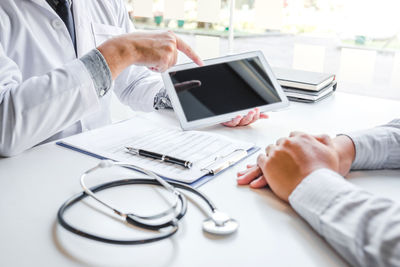 Midsection of man using laptop on table