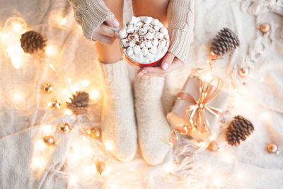 Woman hands holding a cup of coffee. cozy winter concept. hot chocolate or cocoa with marshmallow 