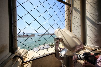 Telescope at observation point by window in city