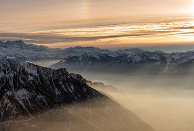 Scenic view of snowcapped mountains against sky during sunset