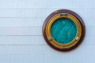 Ship golden portholes on white wooden background. ship window or porthole on white wooden wall.