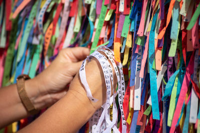 Cropped hand of woman holding colorful clothes