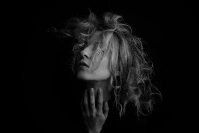 Close-up of woman with hairstyle against black background