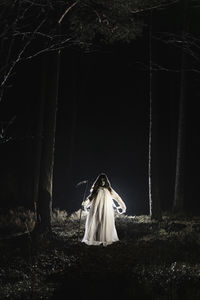 Ghost with scythe walking in forest at night