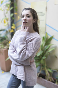 Beautiful teenage girl wearing sweater standing in city