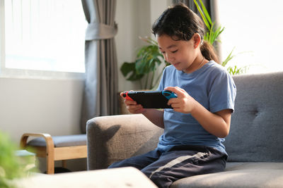 Boy sitting on sofa at home