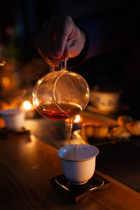 Midsection of person holding tea cup on table