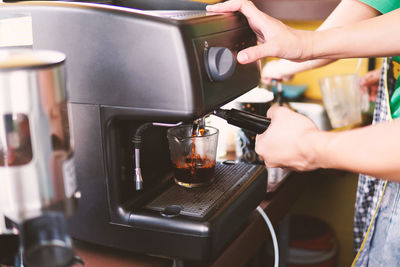 Midsection of man having coffee at cafe