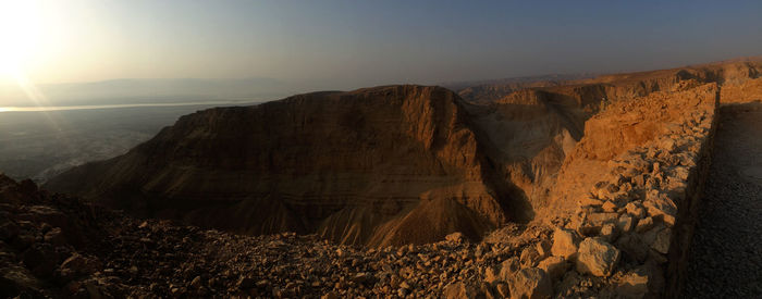Scenic view of mountains, sedimentary rock canyon against sky 