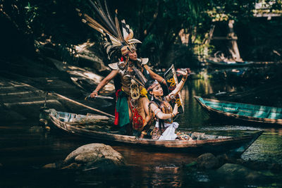 People on boat against trees