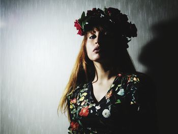 Portrait of woman with red eyes against wall
