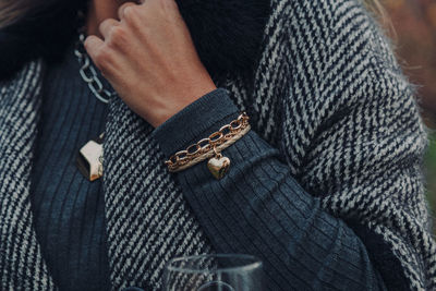 Midsection of woman in warm clothing wearing bracelet