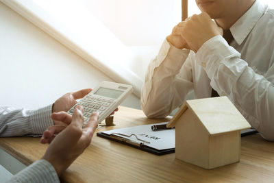 Midsection of woman using smart phone on table