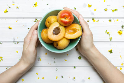 Directly above shot of hand holding fruit on table