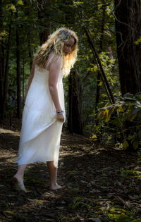 Woman standing on tree trunk