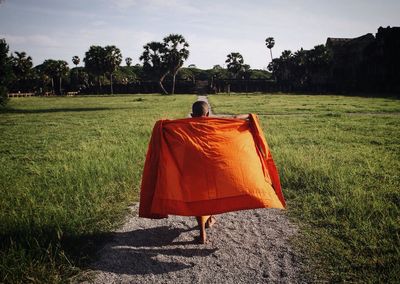 Rear view of monk walking on trail